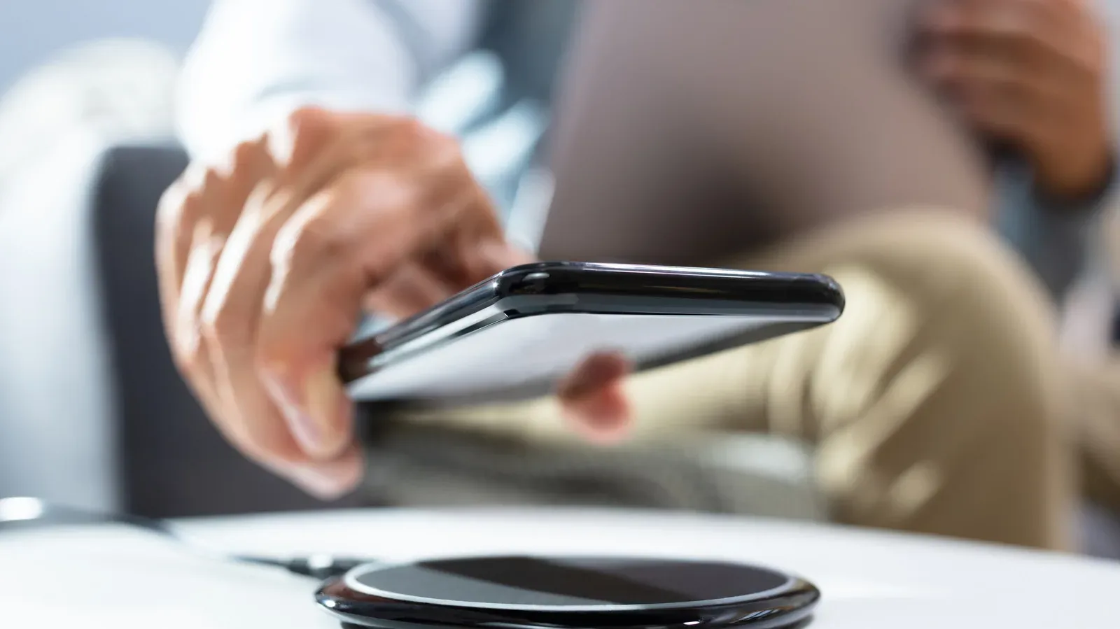 A smartphone aligned on a Qi2 wireless charging pad