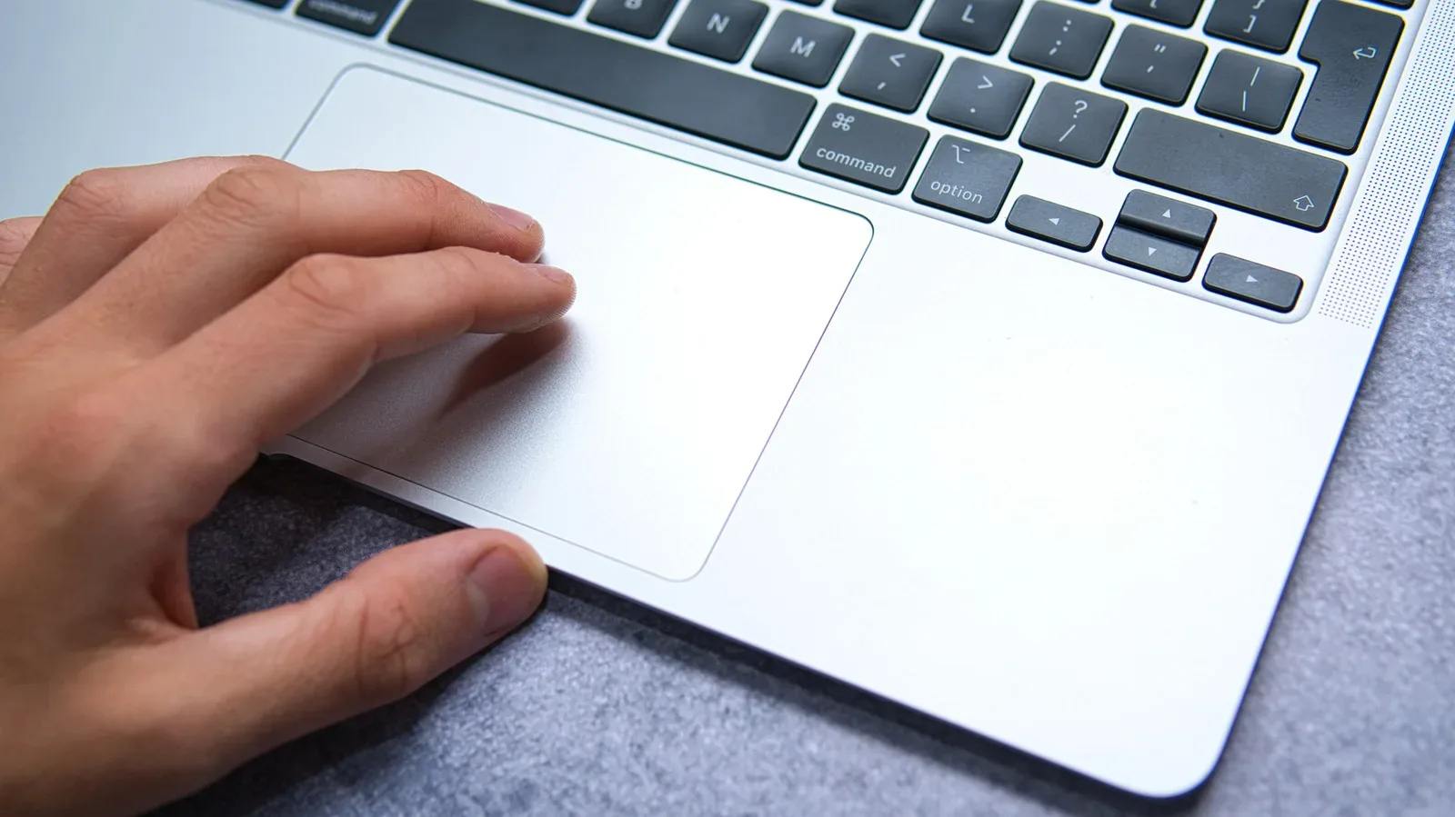 MacBook trackpad showing a two-finger secondary click gesture