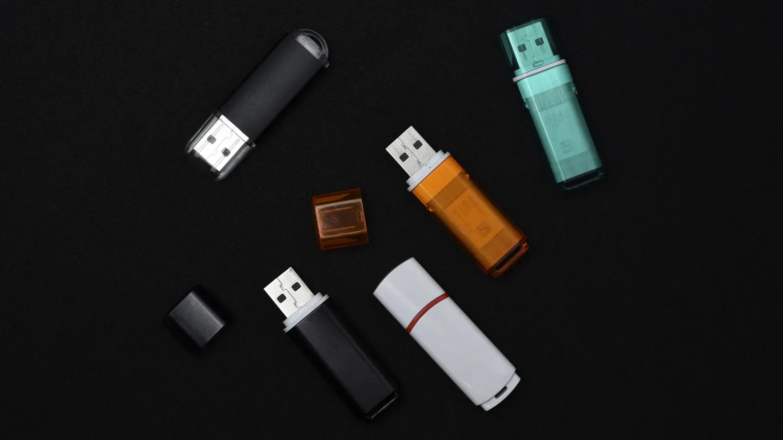 USB flash drives beside a laptop, illustrating differences in speed, security and durability