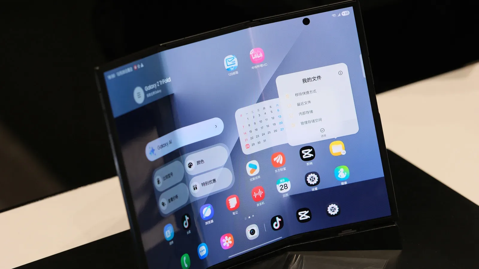 A foldable smartphone open on a clean surface with its flexible inner display visible