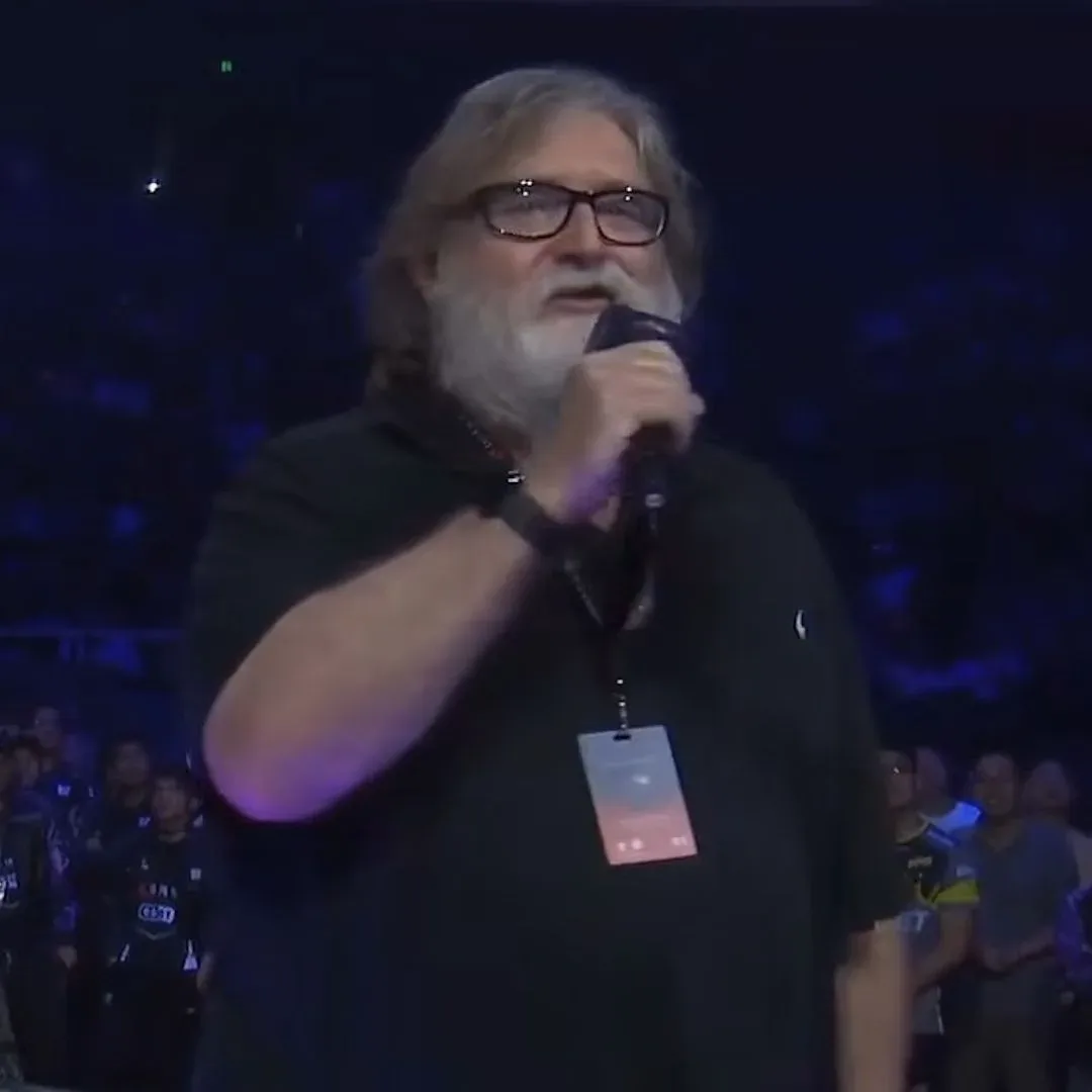 Gabe Newell in a black shirt holding a microphone