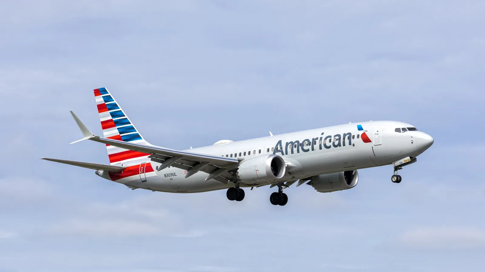 American Airlines passenger jet flying above clouds with satellite Wi-Fi connectivity concept