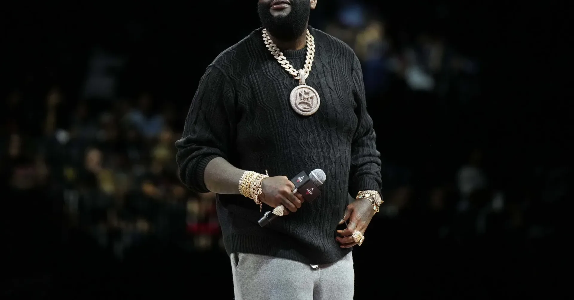 Rick Ross speaking into a microphone during a live appearance