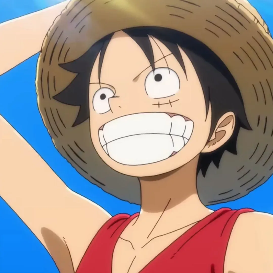 The One Piece explained: A close-up of Luffy smiling while holding his hat in a screenshot of the upcoming reboot, The One Piece