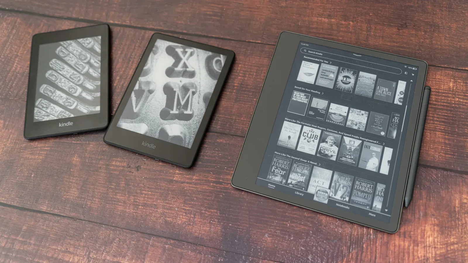 An older Kindle e-reader displaying a book on its grayscale screen