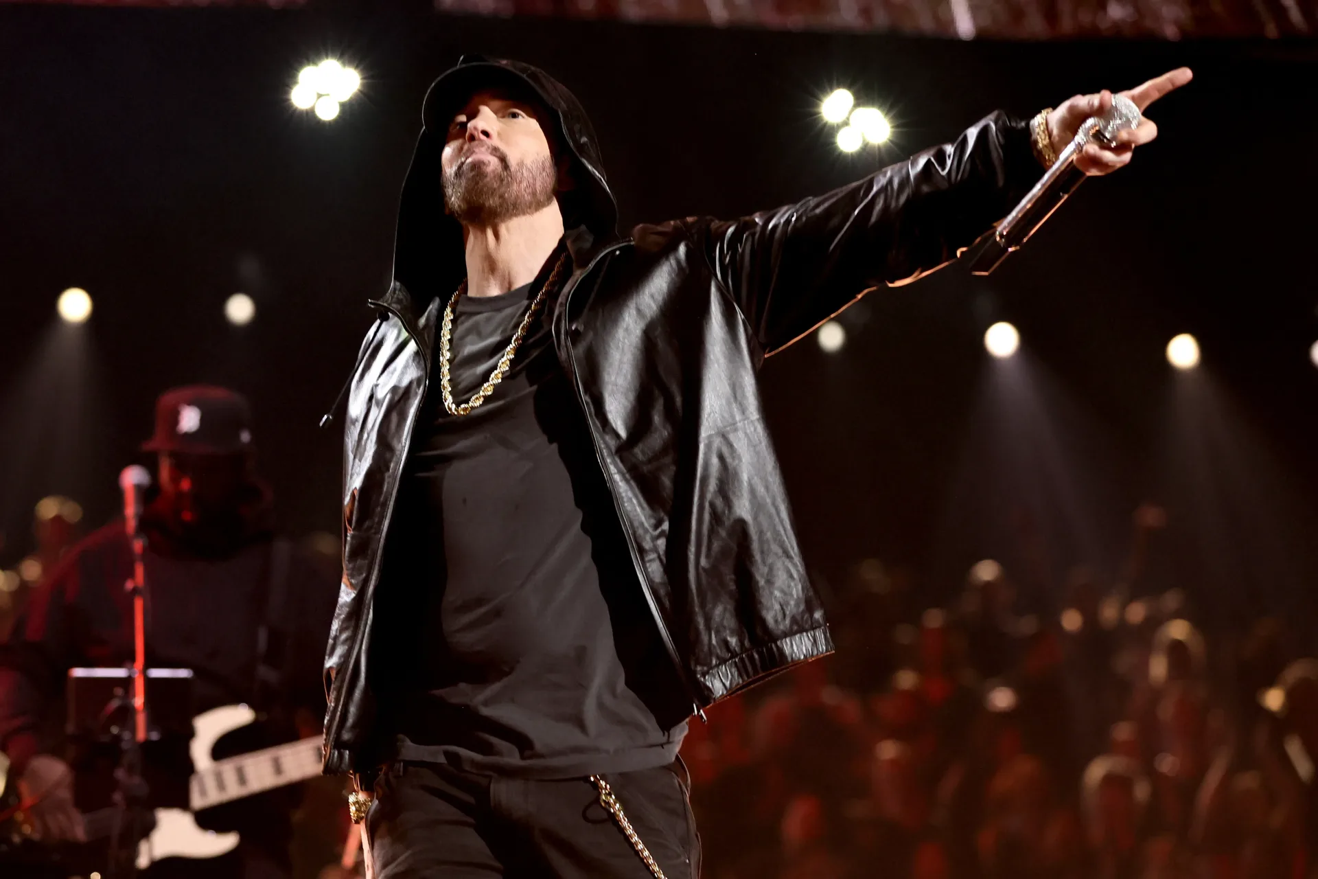 Eminem performing onstage under concert lighting