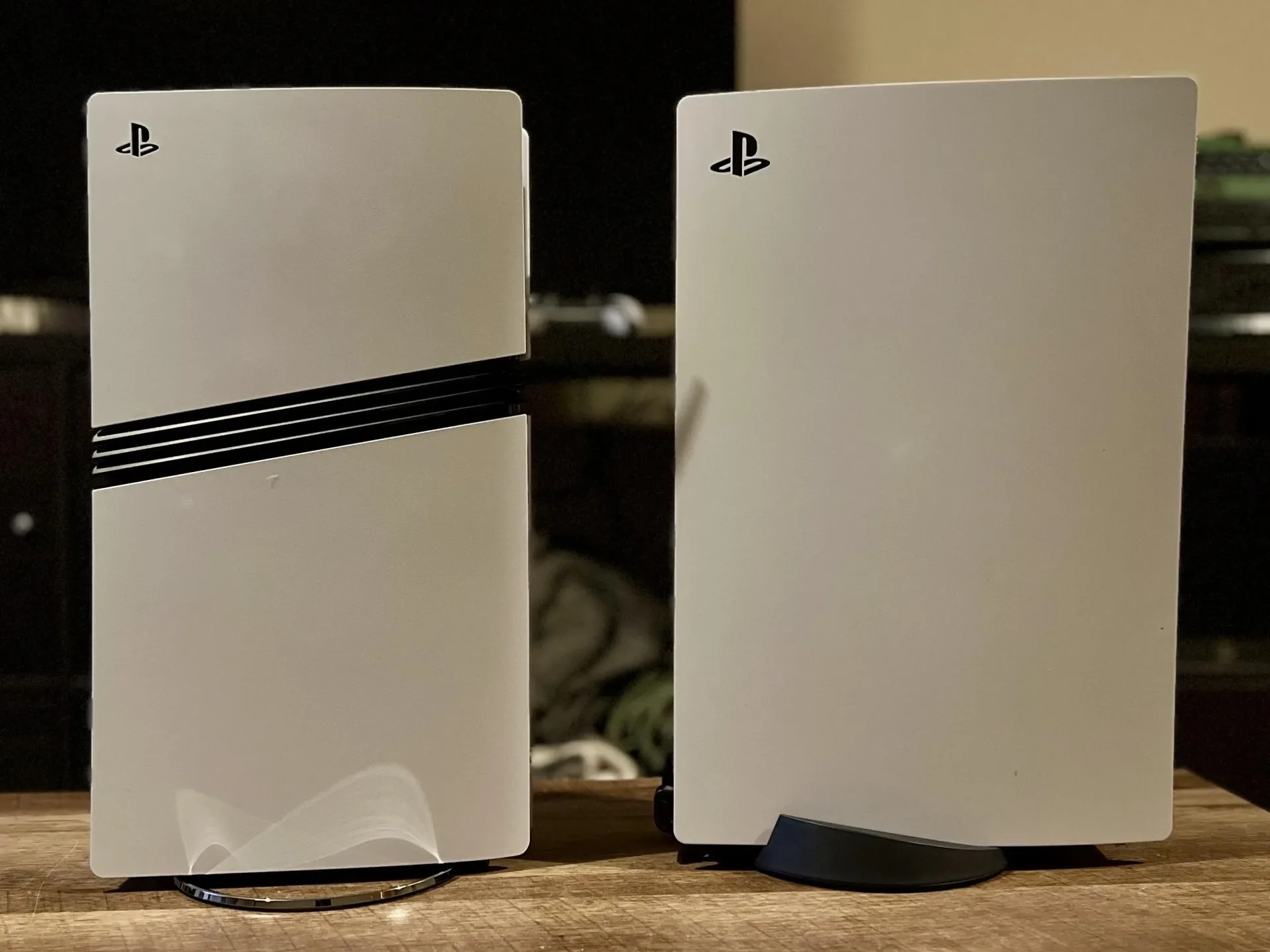 PS5 Pro and PS5 original console side on on a wooden table
