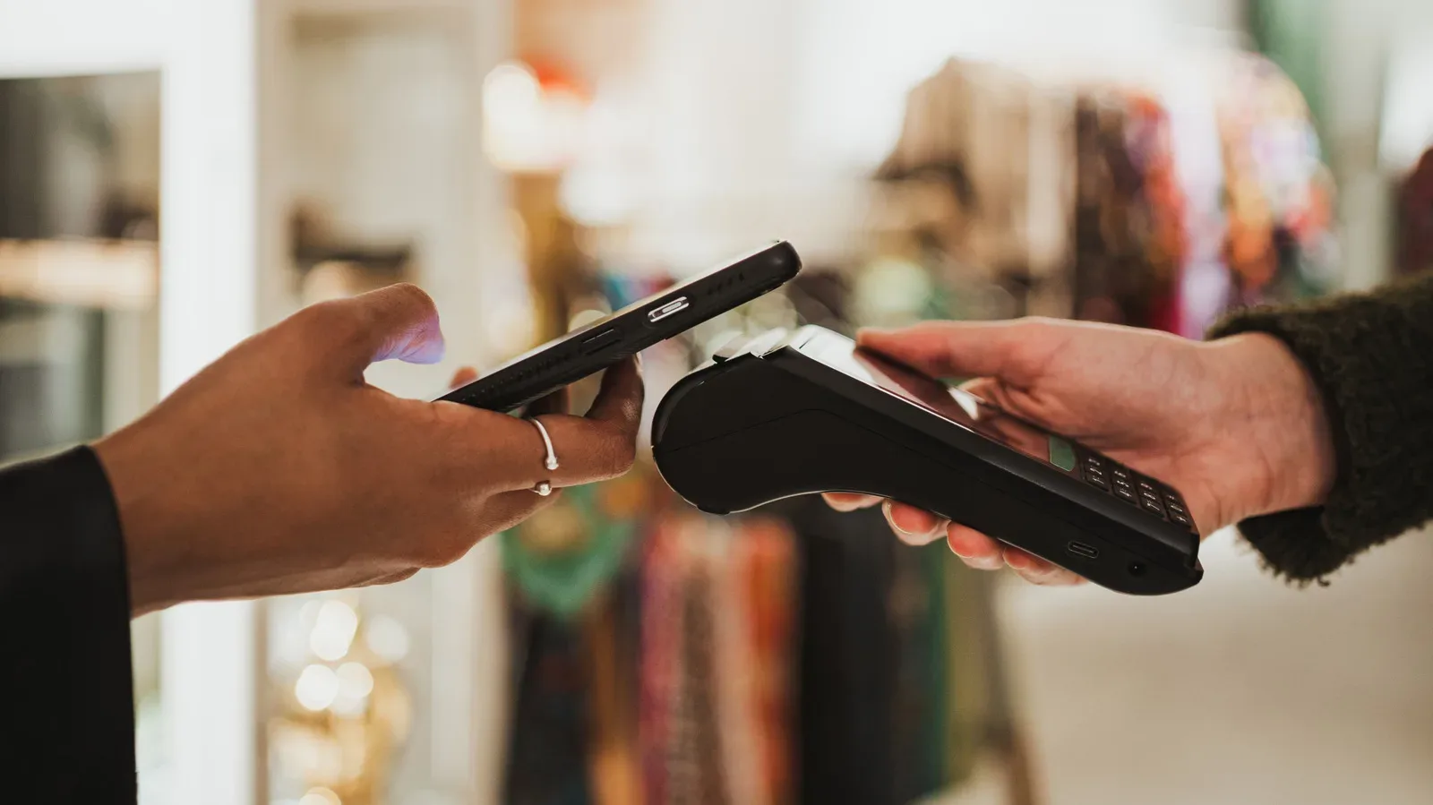 An iPhone held near a contactless payment terminal