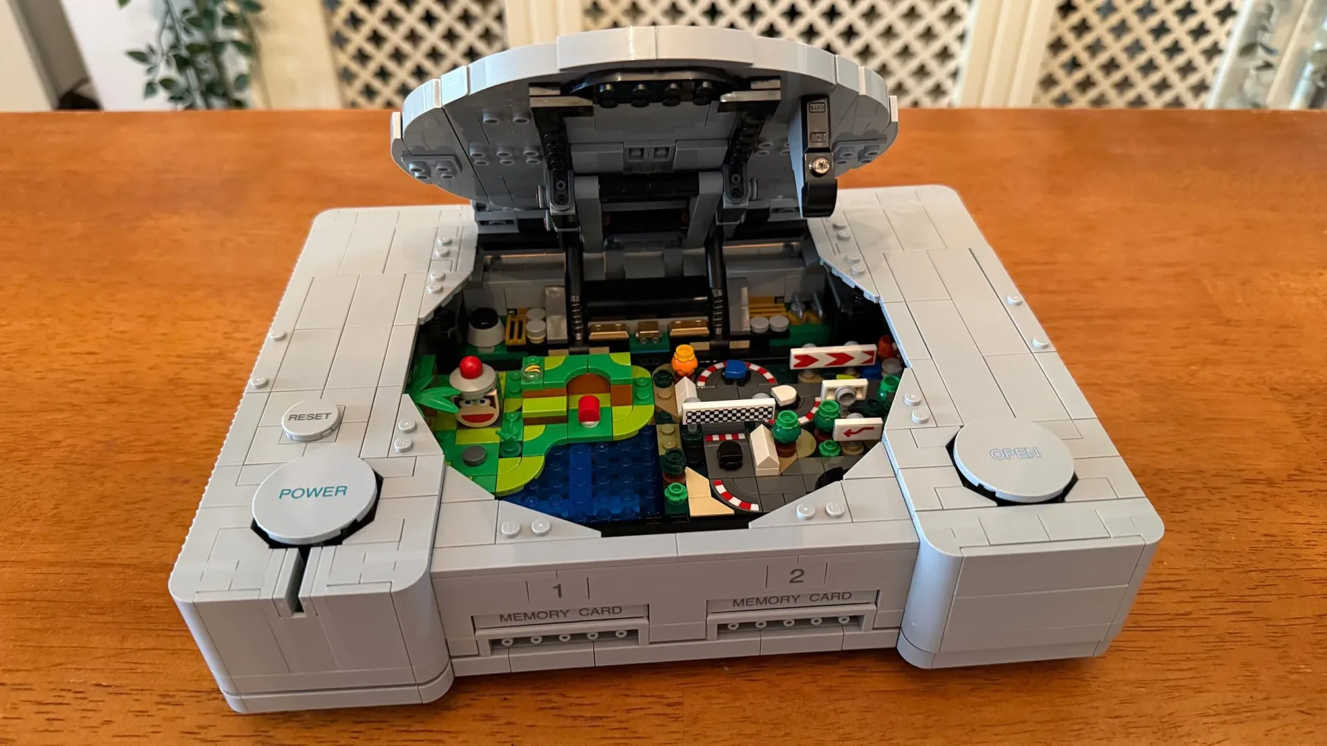 Fan-built Final Fantasy VII LEGO diorama displayed across a LEGO PlayStation console and controller