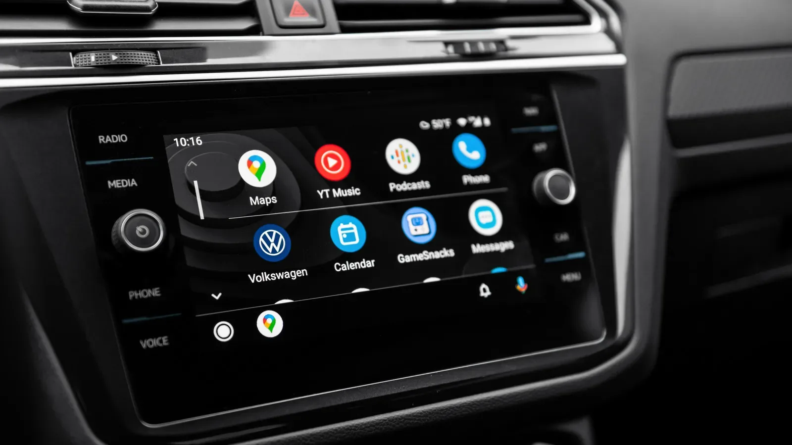 A foldable smartphone closed beside an Android Auto car display