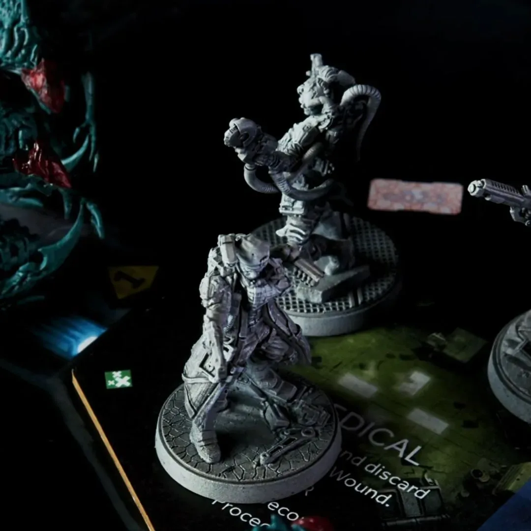 Miniatures from Nemesis Legacy face each other in a dark environment