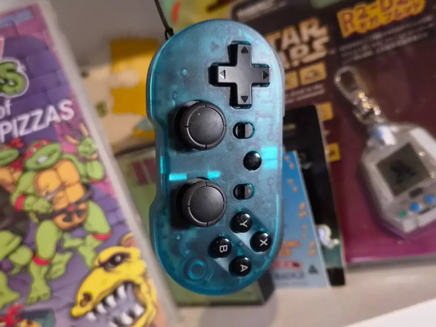 Photo of the CRKD Atom+ controller dangling in front of a shelf.