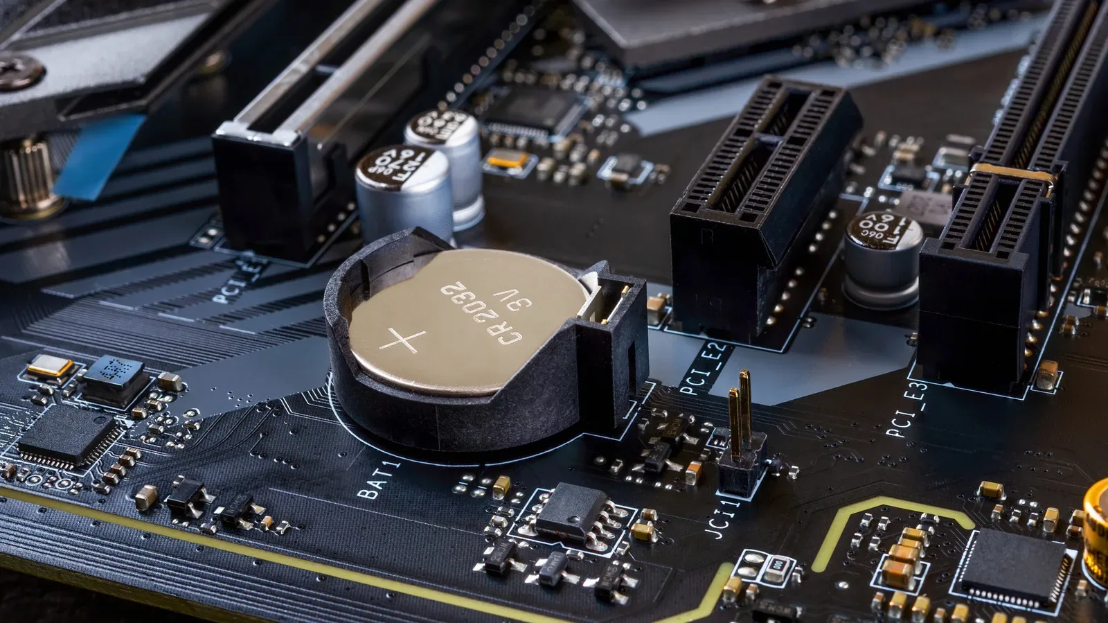 A silver CMOS coin-cell battery installed in a desktop PC motherboard