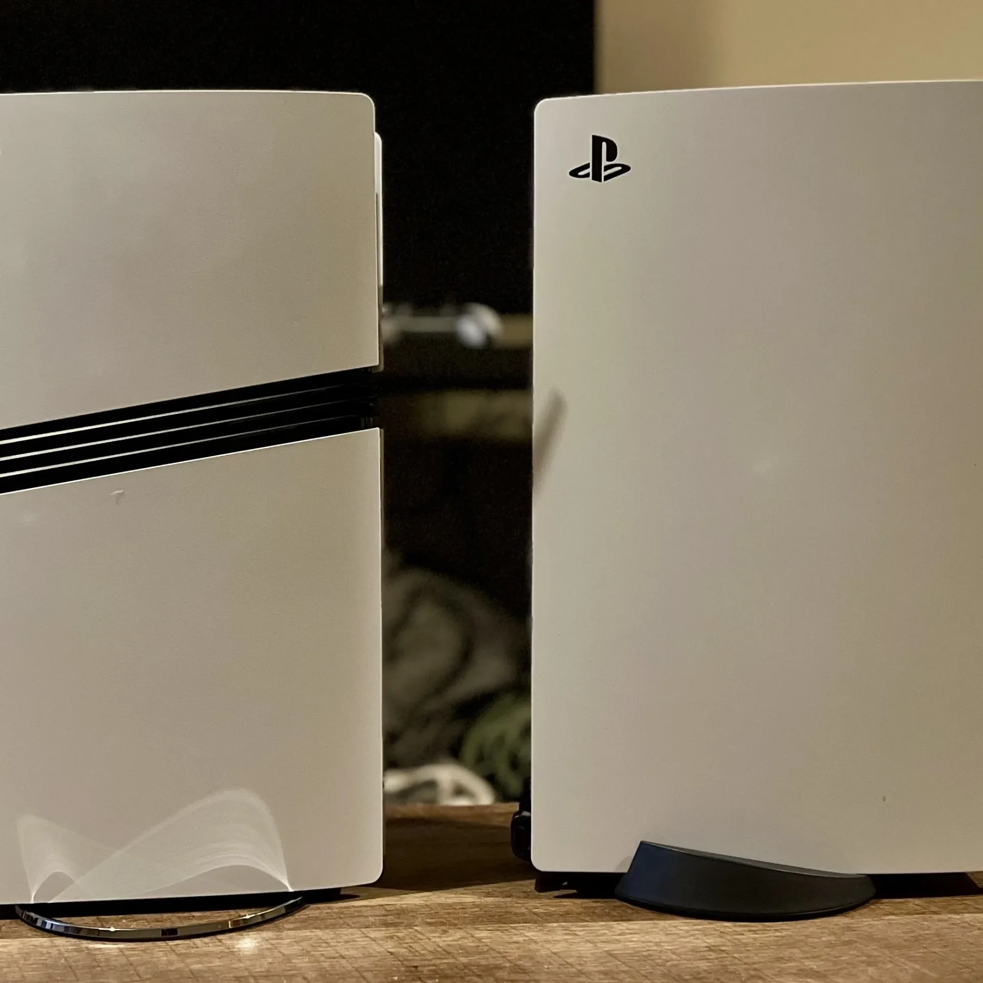 PS5 Pro and PS5 original console side on on a wooden table