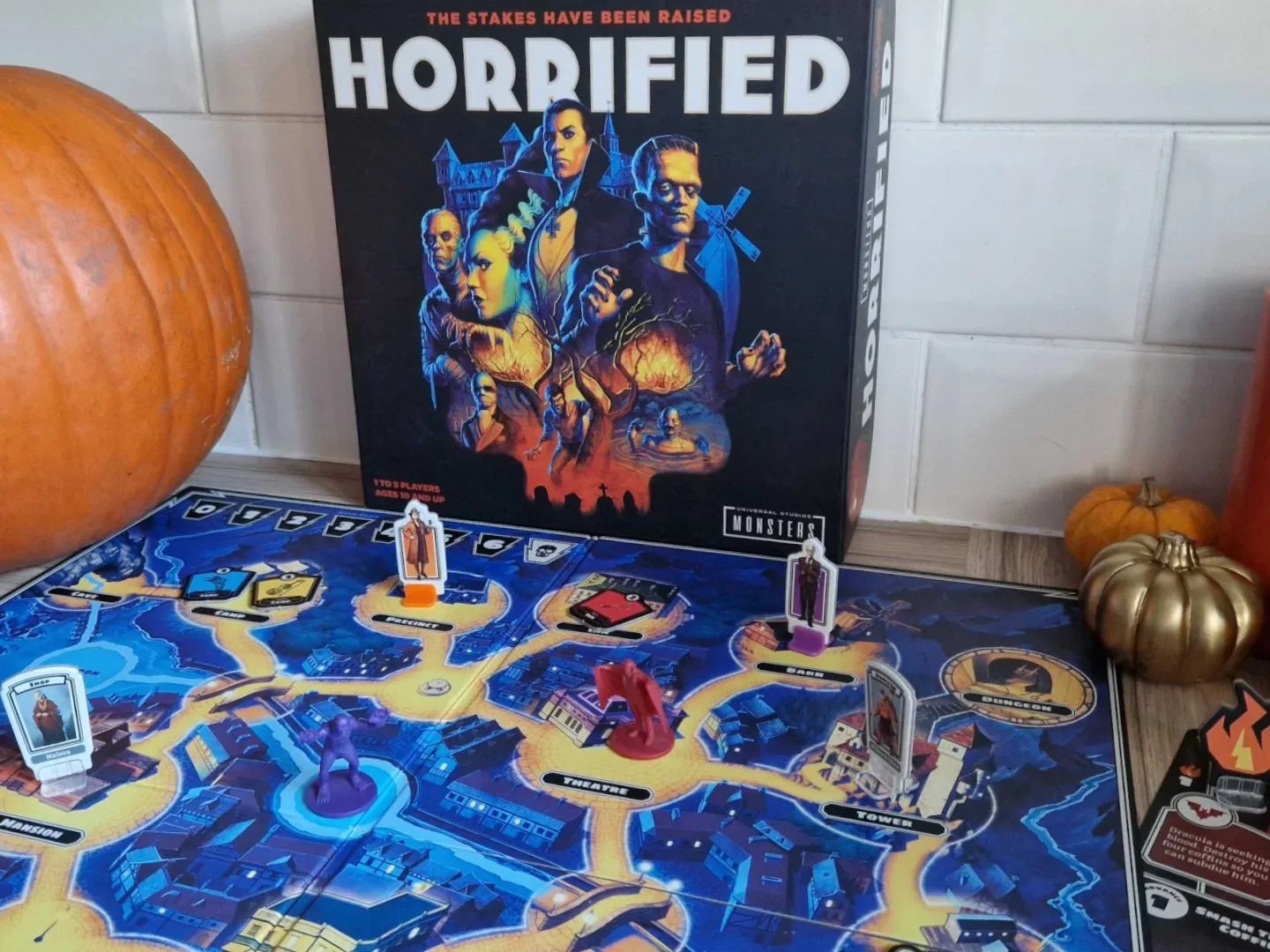 Horrified board game with pumpkins, tokens, and candles