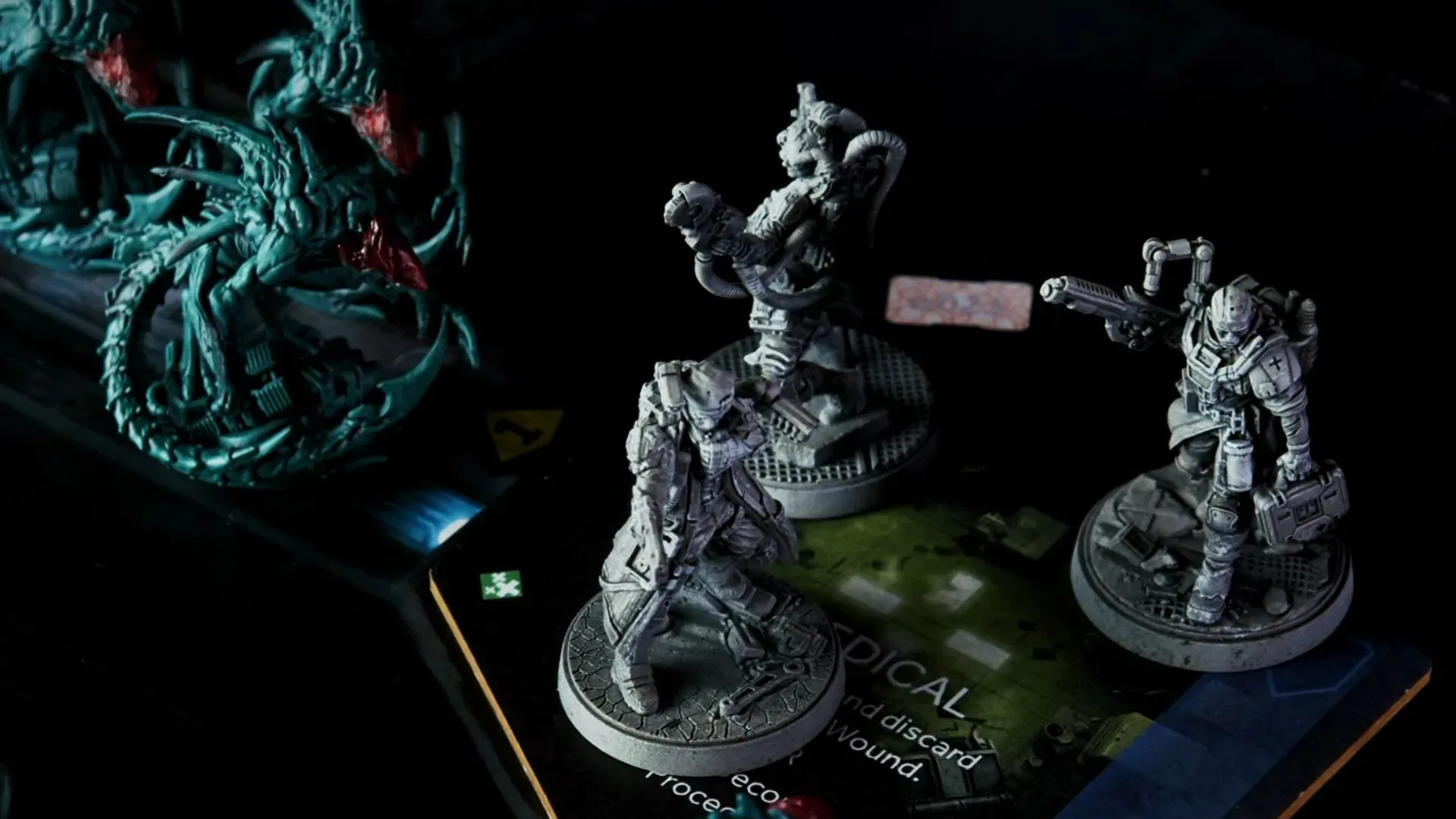 Miniatures from Nemesis Legacy face each other in a dark environment
