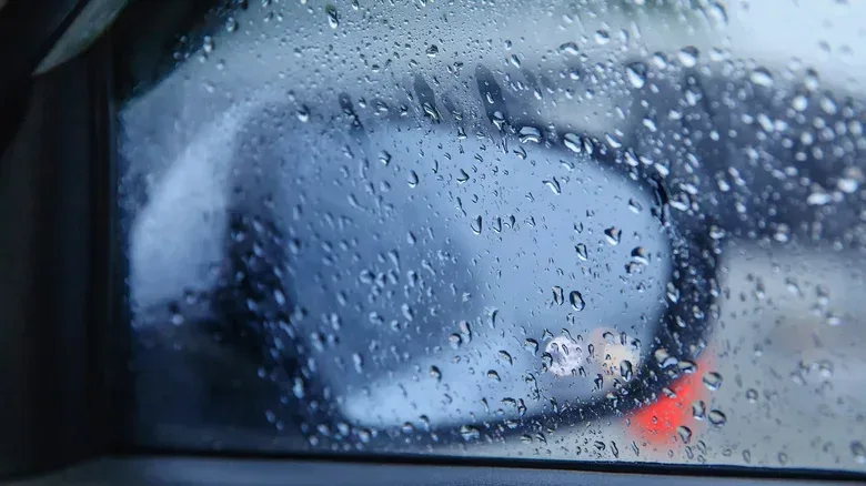 Car following traffic on a wet road, illustrating driver-assistance limitations