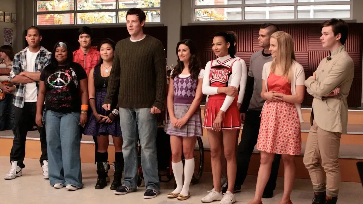 Glee revival discussion artwork featuring a show choir stage and microphones