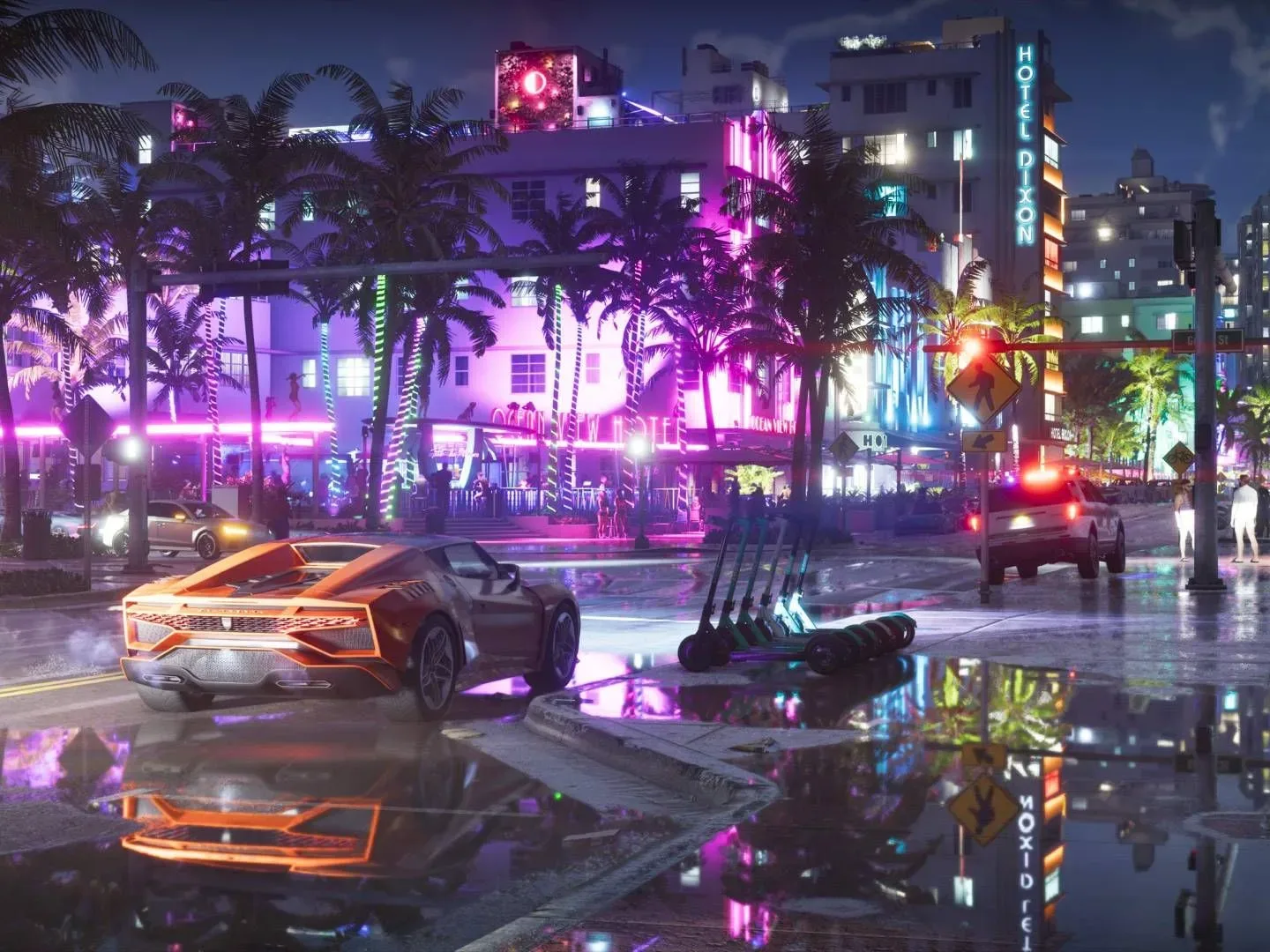 GTA 6 screenshot shows a sports car parked on a street at night, looking at an illuminated row of buildings.