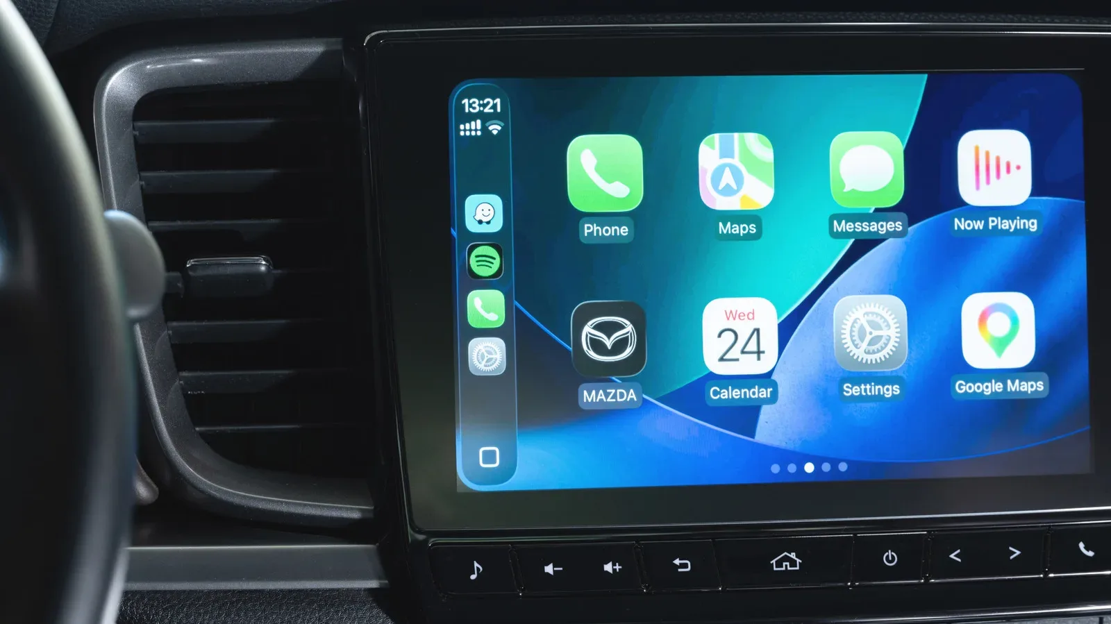 A smartphone mounted in a car displaying navigation while connected to CarPlay or Android Auto