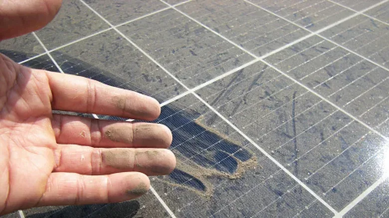 A soft brush cleaning a solar panel with low-mineral water