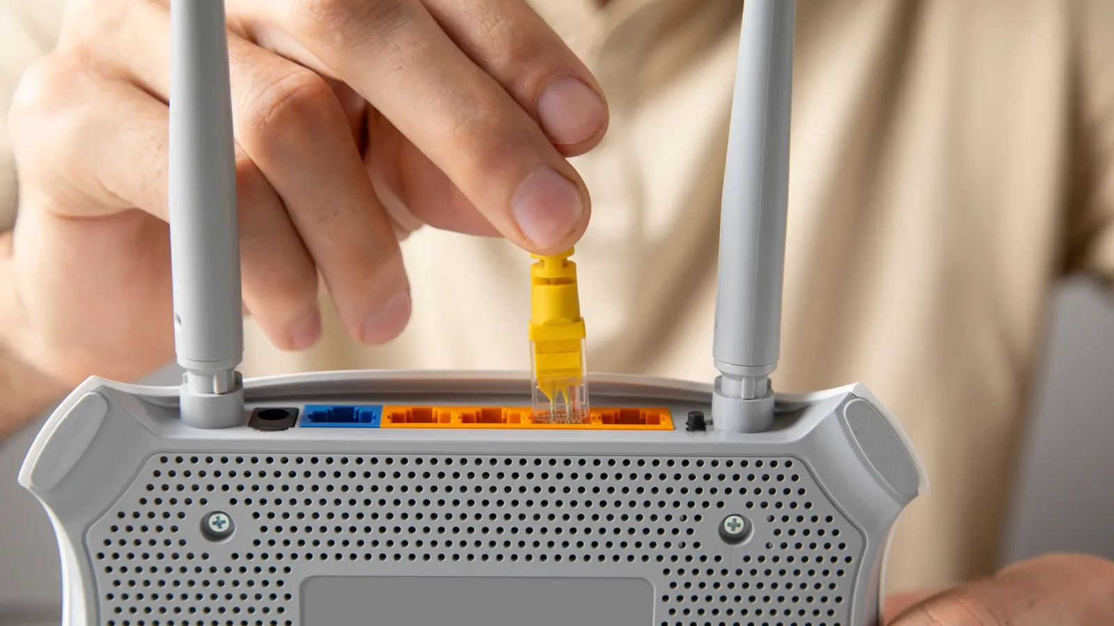 An Ethernet cable connector plugged into the rear network port of a desktop PC