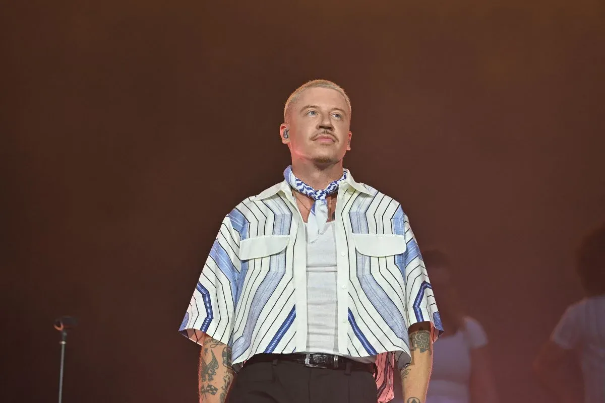 Macklemore performing onstage during a live concert