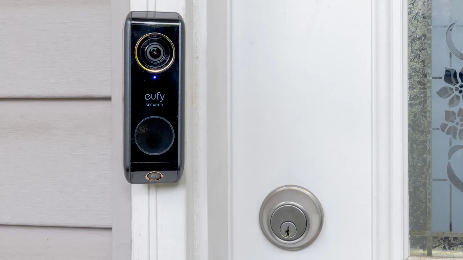 Video doorbell mounted beside a front door overlooking an approach path