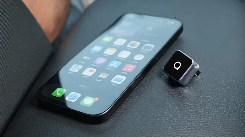 USB-A and USB-C wireless CarPlay adapters beside an iPhone