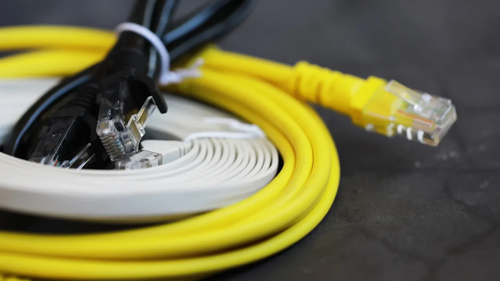 Outdoor-rated Ethernet cable secured along an exterior wall