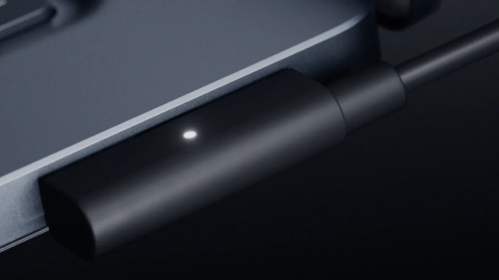 A magnetic USB-C laptop charging connector aligned with a Surface Laptop Ultra port