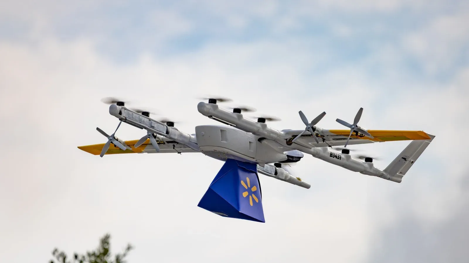 A small delivery drone flying above a suburban neighborhood