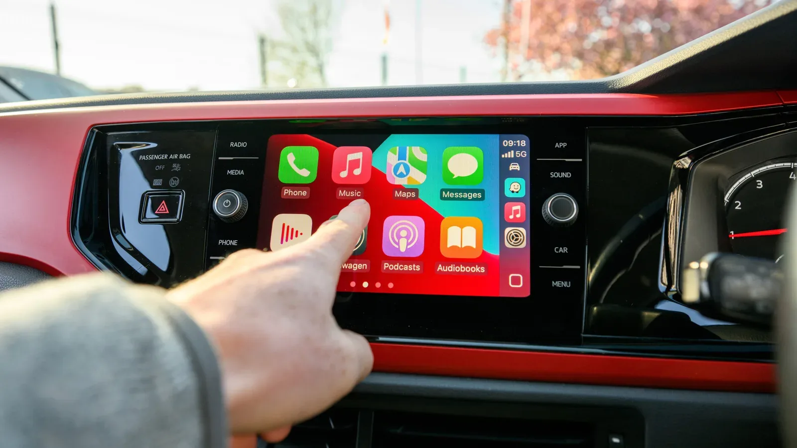 Car dashboard displaying Apple CarPlay navigation and audio controls