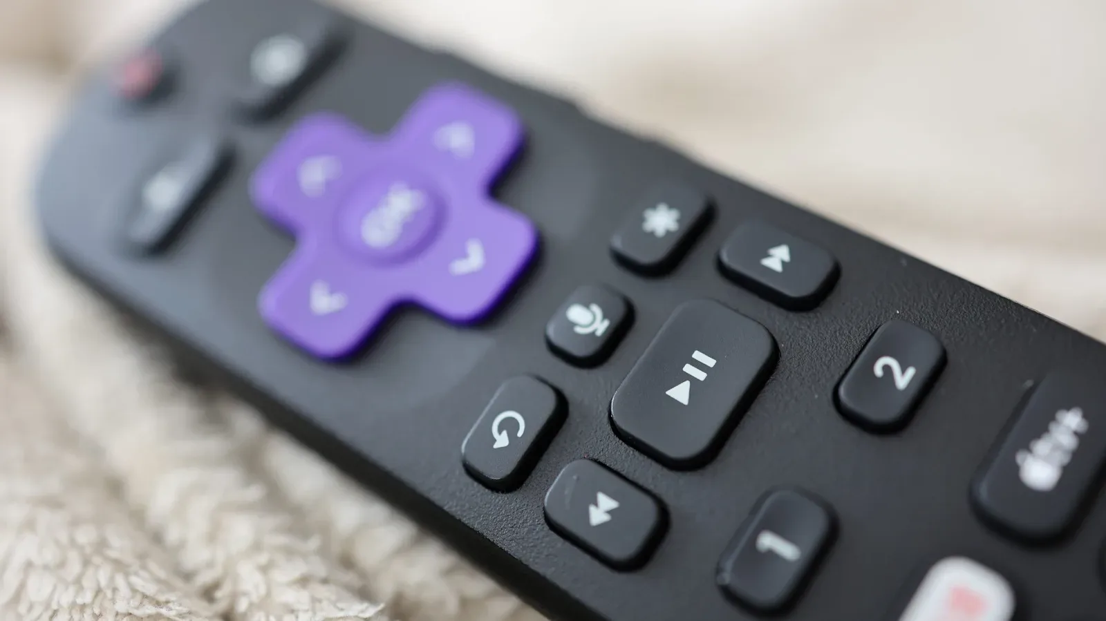 A Roku remote showing the star button above the fast-forward control