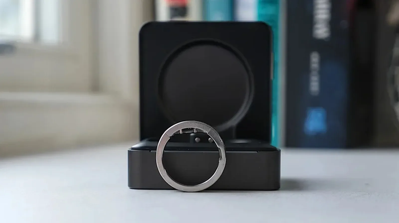 A smart ring beside a smartphone displaying a health app dashboard
