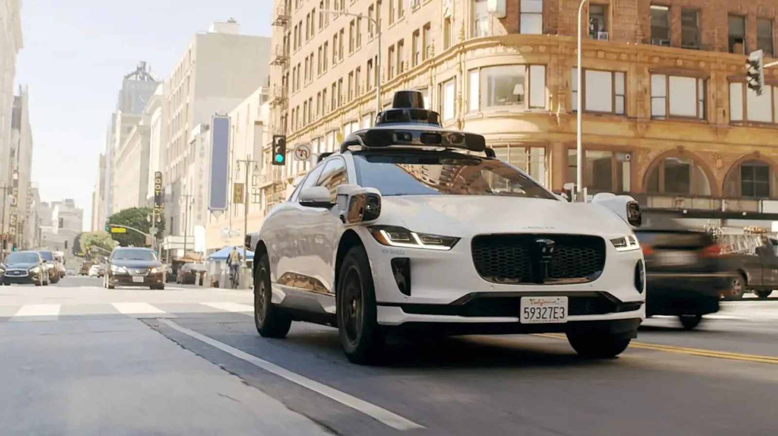 A driverless robotaxi stopped near emergency vehicles on a city street