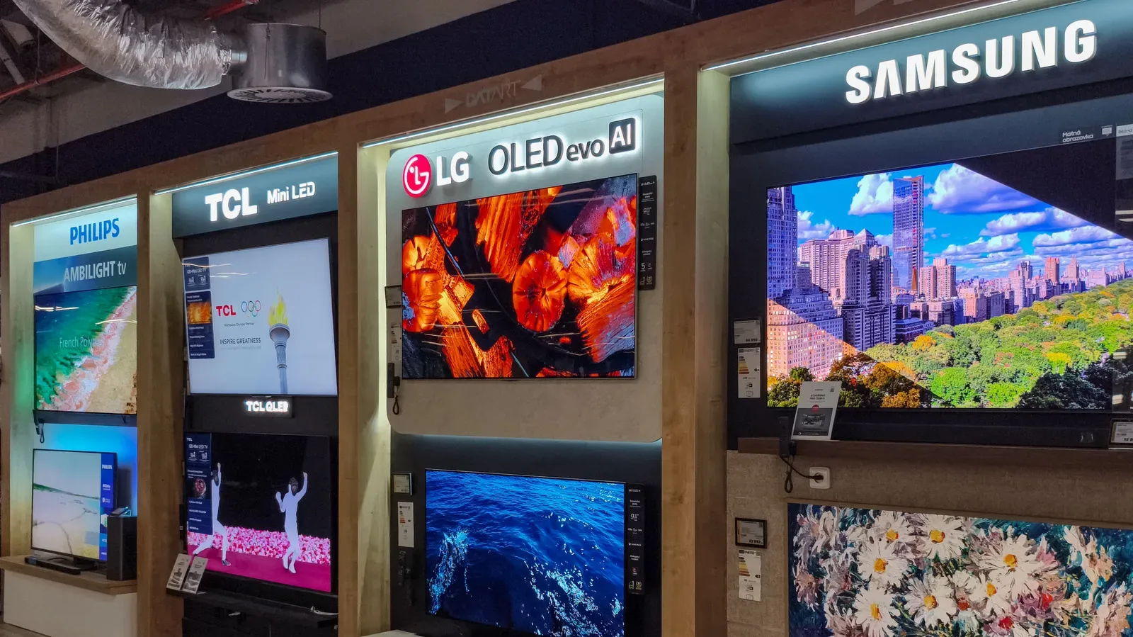 A gaming laptop beside a television displaying a game menu