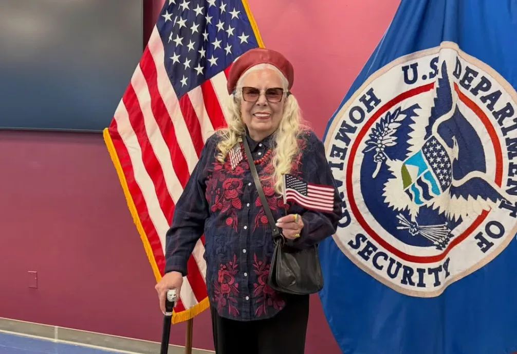 Joni Mitchell holding an American flag after becoming a U.S. citizen