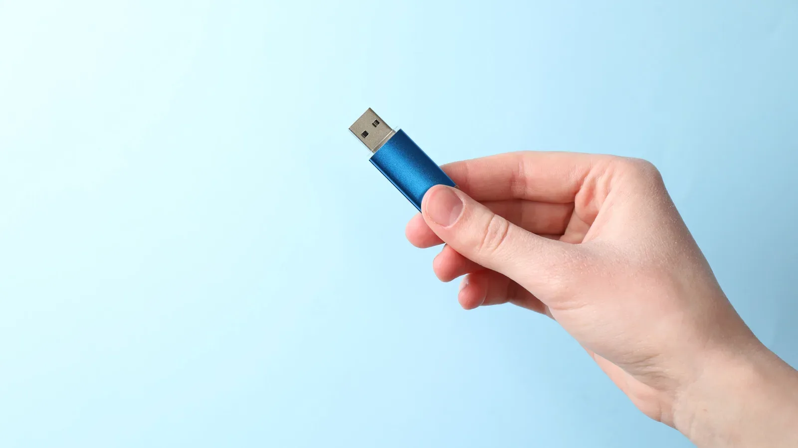 An old USB flash drive connected to a laptop USB port