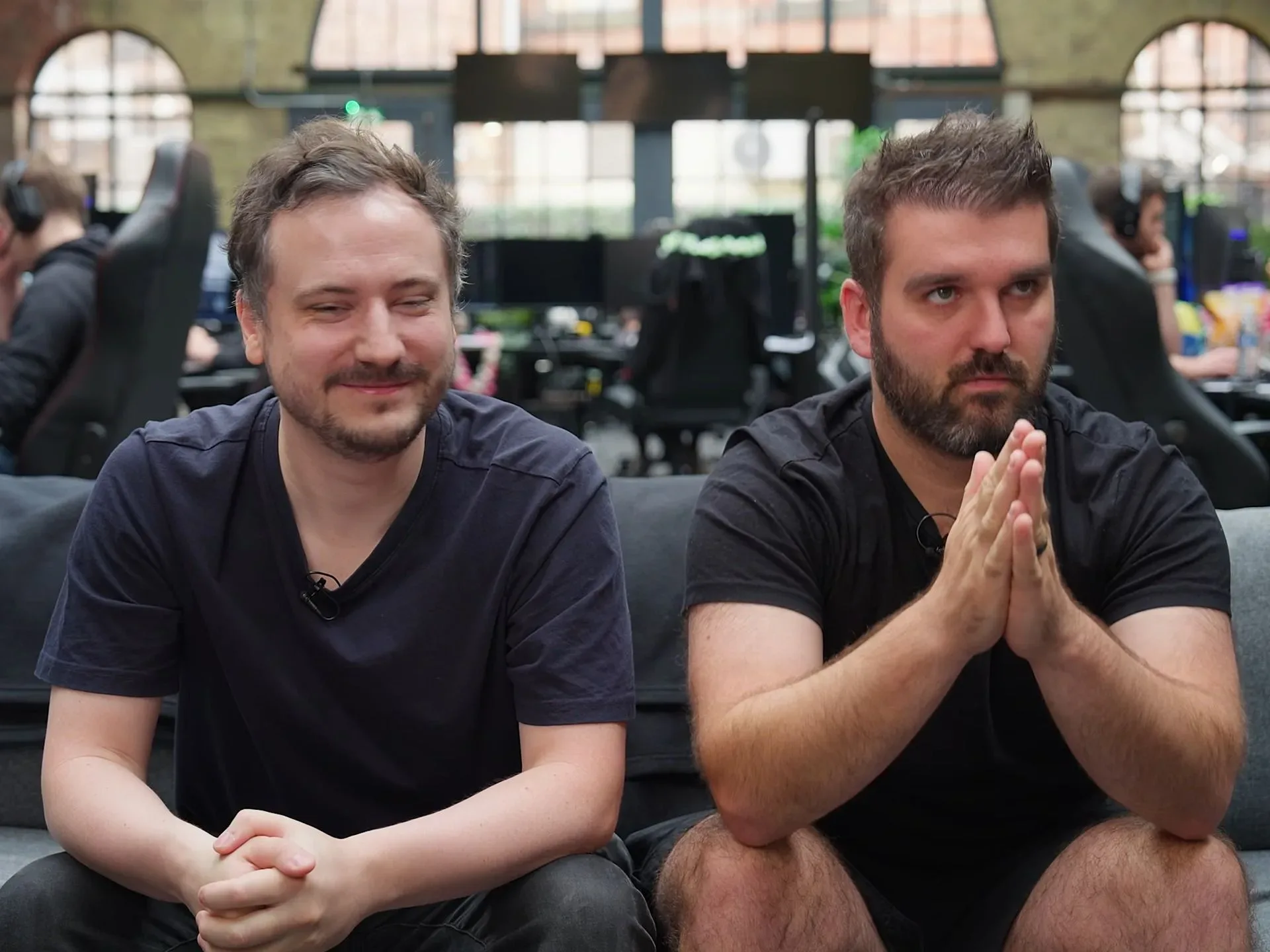 Two Wardogs developers sitting on a gray couch