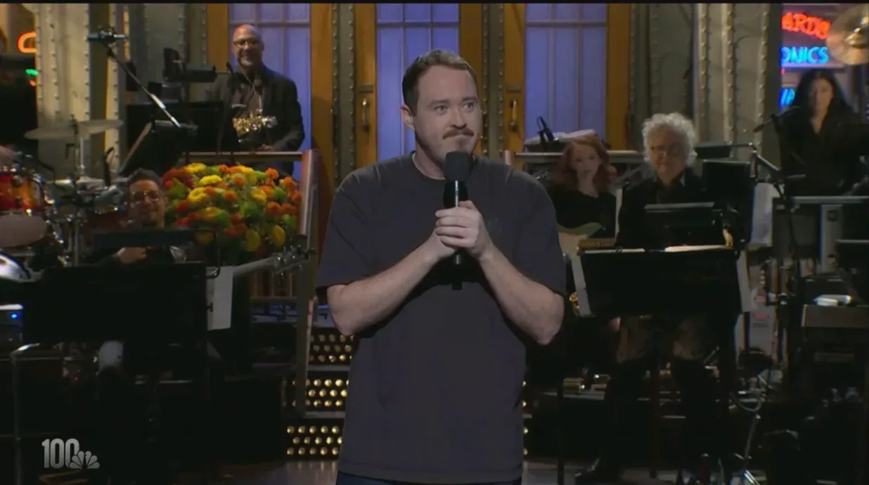 Shane Gillis delivering a monologue on the Saturday Night Live stage
