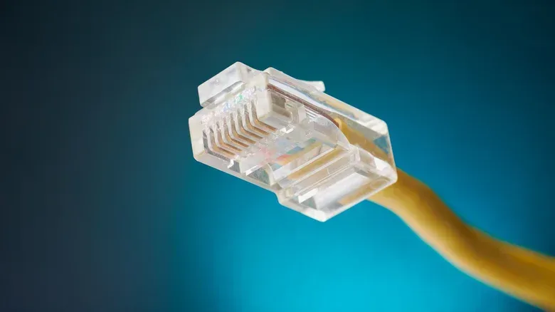 An Ethernet cable routed with slack behind a gaming desk