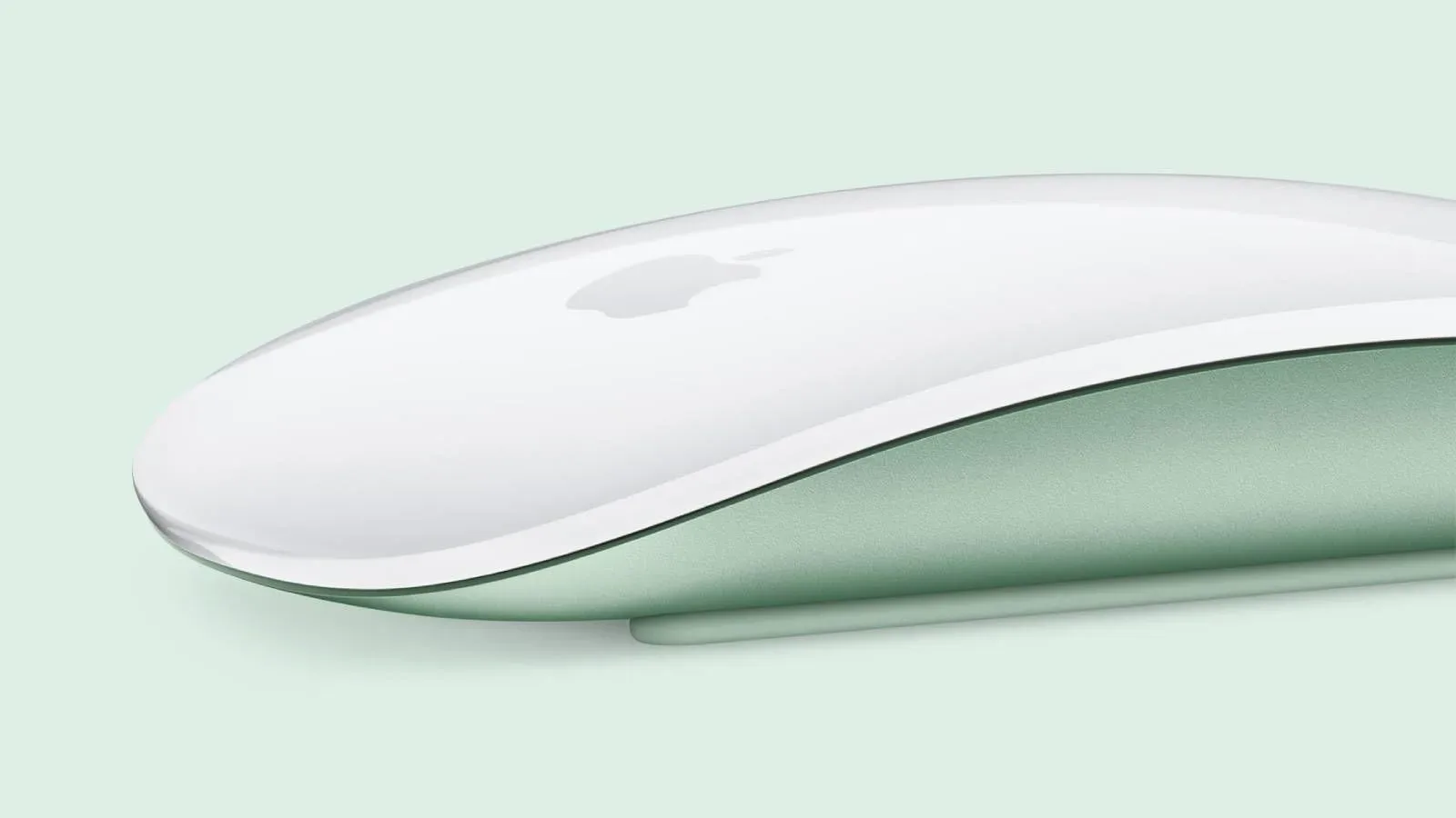 Apple Magic Mouse beside a Mac desktop setup