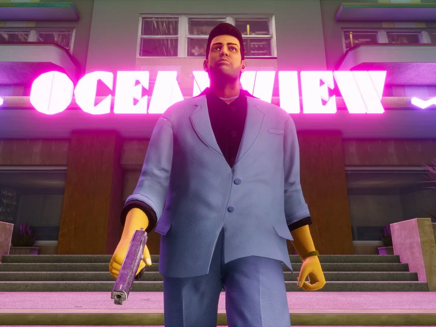 GTA: Vice City protagonist Tommy Vercetti walks out of the Oceanview club while wearing a grey suit and wielding a pistol in his rand hand