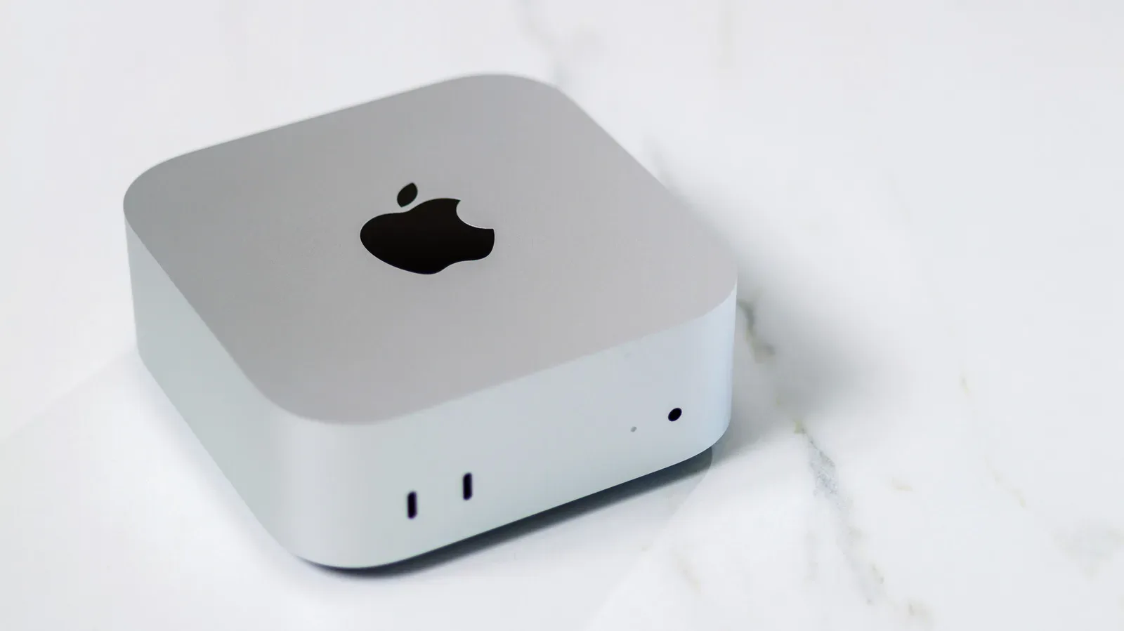 Apple Mac mini connected to a monitor, keyboard and mouse on a gaming desk