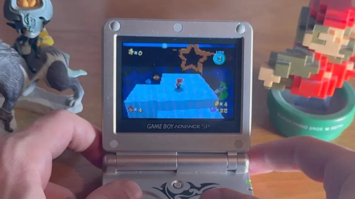 A Game Boy Advance SP displaying a blockier handheld adaptation of Super Mario Galaxy