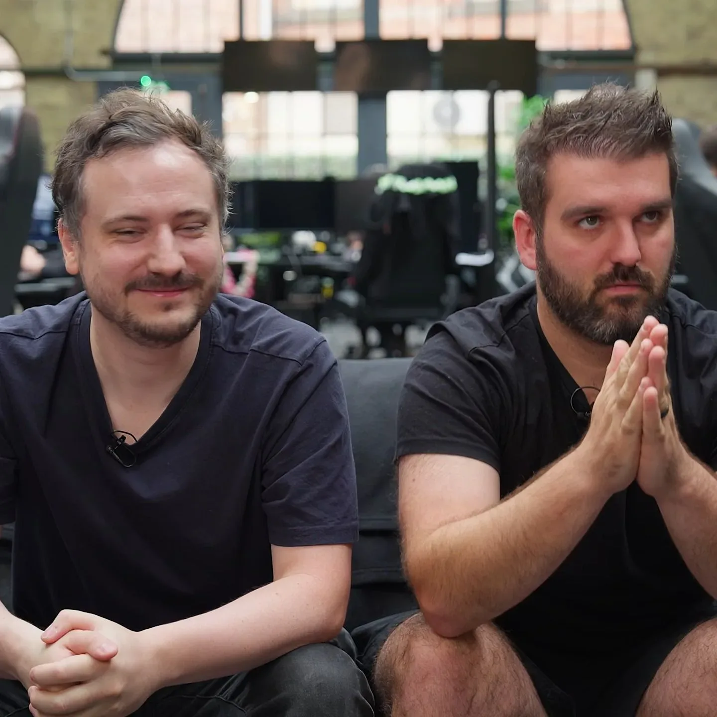 Two Wardogs developers sitting on a gray couch