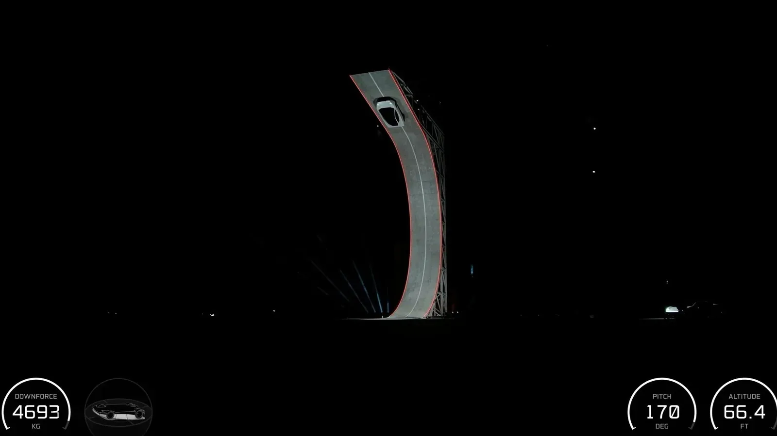 Tesla Roadster hanging upside-down at the top of a C-shaped ramp