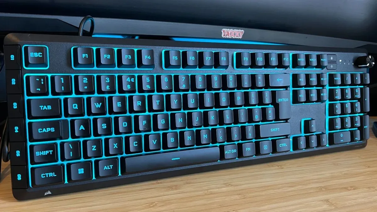 Corsair Skiff 100 Plus gaming keyboard standing upright on a wooden desk