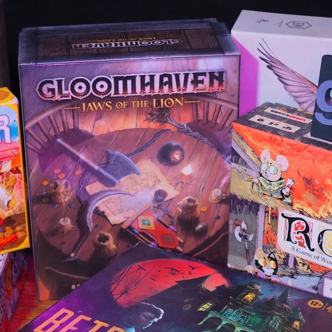 A collection of the best board games, standing in a row on a wooden table and against a dark background, with a GamesRadar+ logo visible